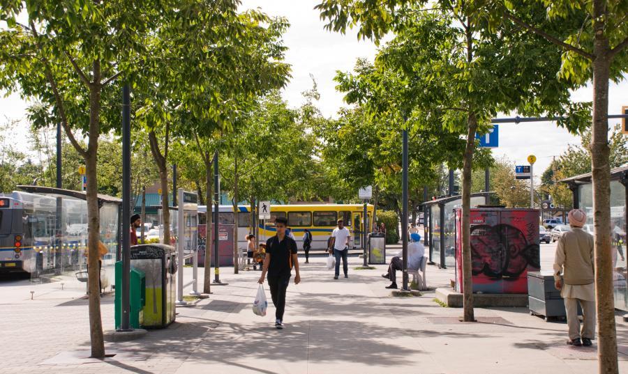 People walk through Newton Exchange bus loop